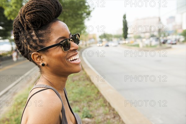 African American woman with braids laughing near street