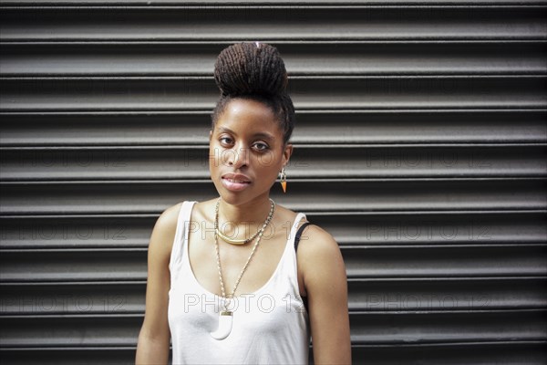 Portrait of African American woman with braids near metal wall