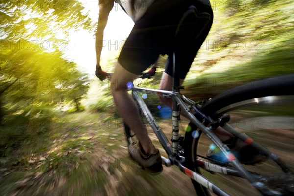 Blurred view of Caucasian man riding dirt bike in forest