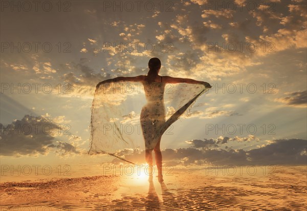 Caucasian woman under dramatic sunset sky