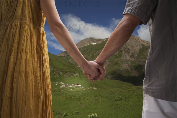 Close up of Caucasian couple holding hands on remote hillside