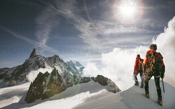 Caucasian hikers standing on snowy mountain top