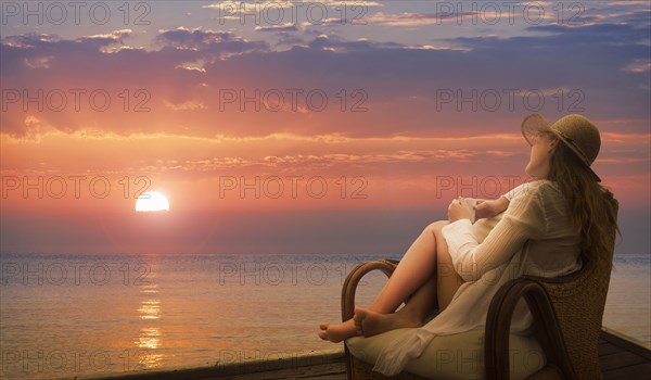 Caucasian woman admiring sunset on beach