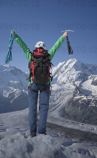 Caucasian hiker cheering on mountaintop