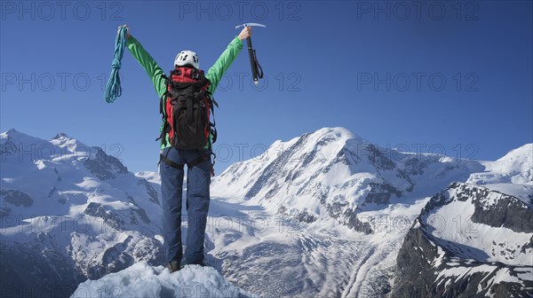 Caucasian hiker cheering on mountaintop