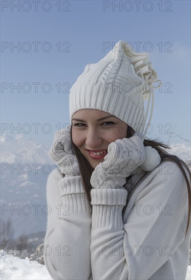 Caucasian woman wearing hat and gloves in snow