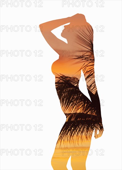 Silhouette of Caucasian woman with palm leaves and sunset