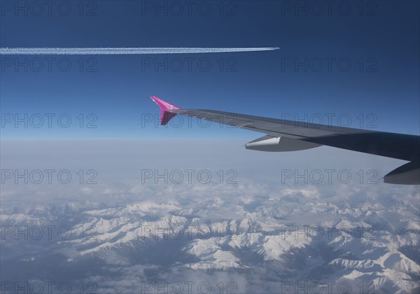 Airplanes flying in blue sky over Swiss Alps