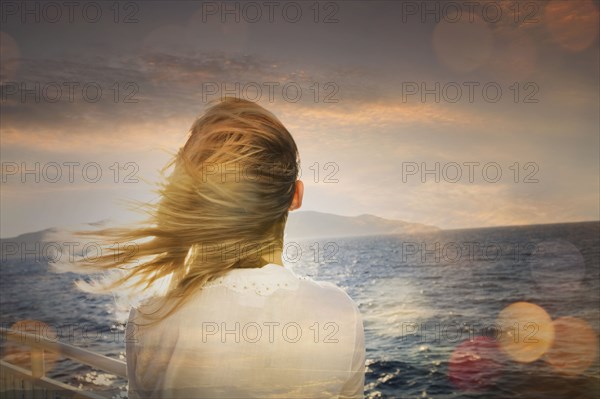 Caucasian woman standing on boat admiring ocean