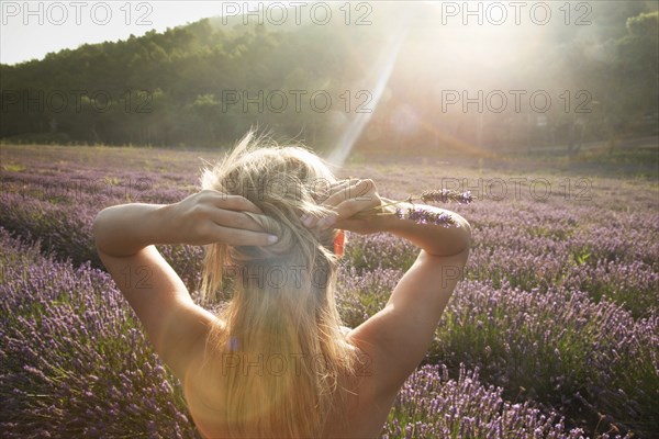 Caucasian woman admiring field of flowers