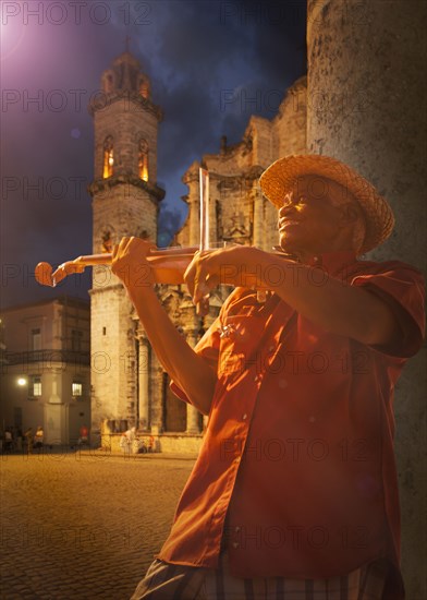 Hispanic musician playing violin on Havana street