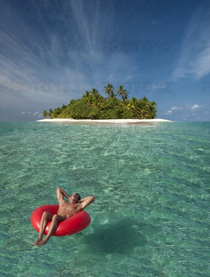 Caucasian man floating near tropical island