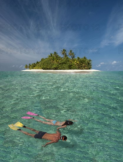 Caucasian couple snorkeling off tropical island