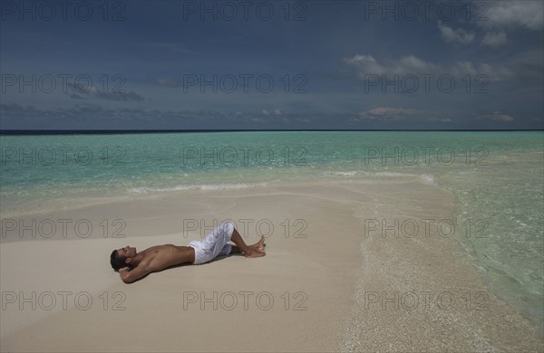 Caucasian man laying on beach