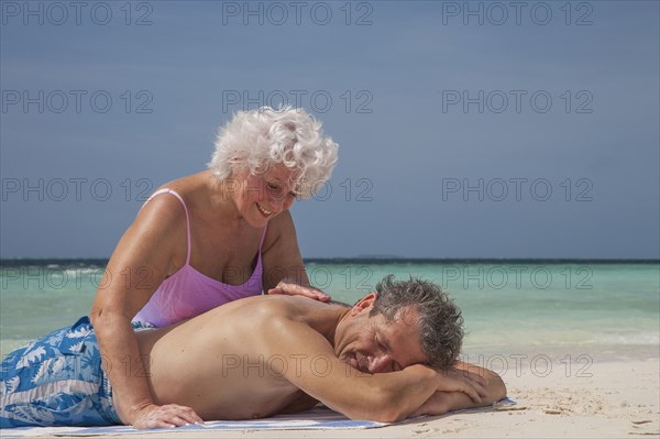 Older Caucasian couple relaxing on beach