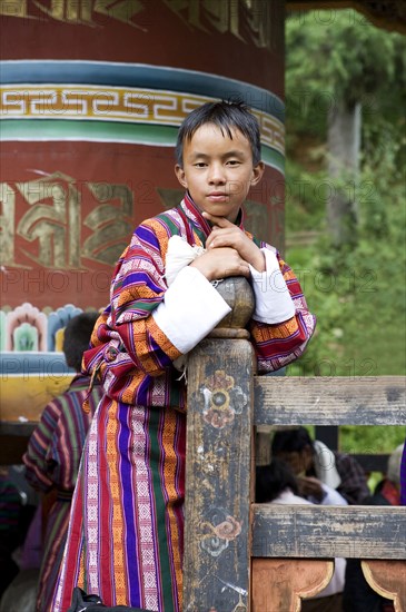 Asian boy leaning on fence post