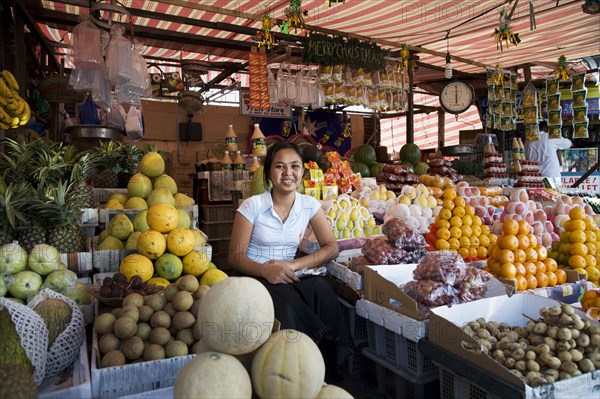Asian vendor smiling at market