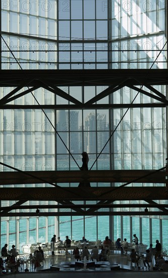 People in modern glass atrium