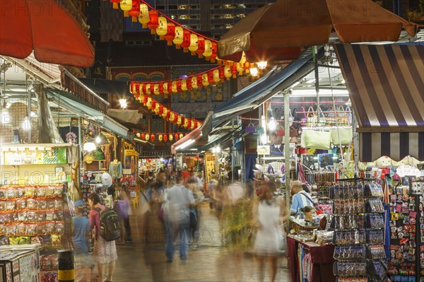 Blurred view of people shopping in outdoor market at night