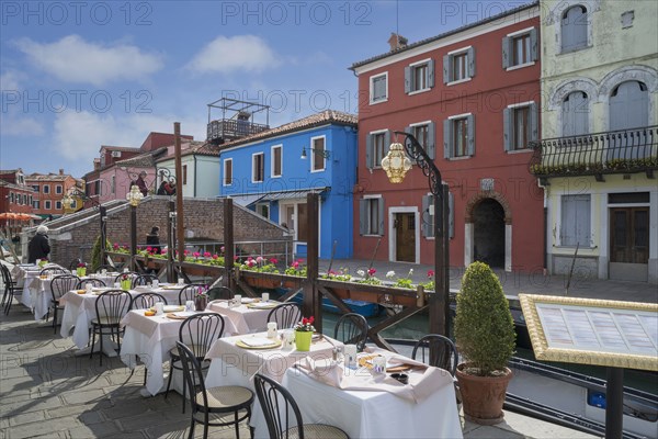 Sidewalk cafe overlooking Venice Burano canal
