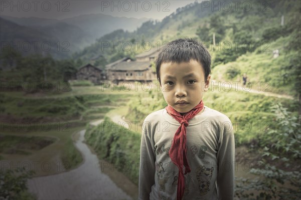 Chinese boy standing in rice paddy fields