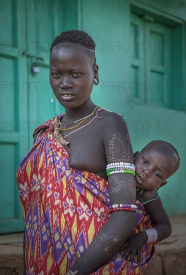 Black woman carrying daughter in sling