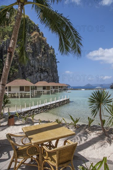 Dock and huts on tropical beach