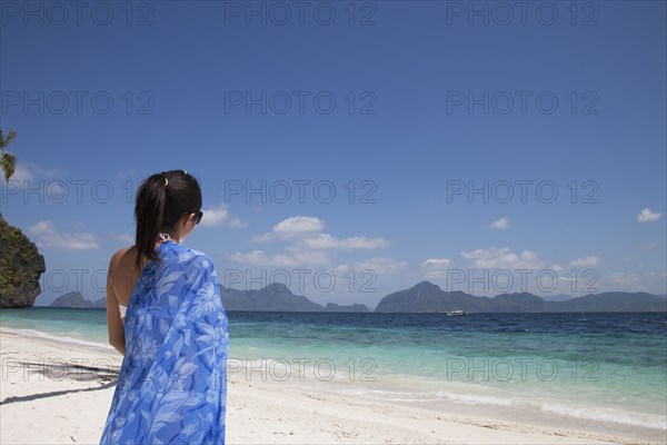 Asian woman walking on beach