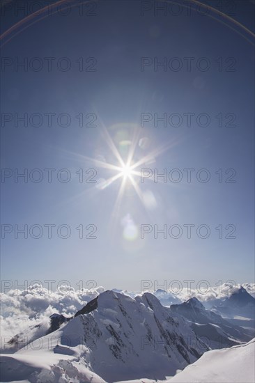 Sunshine over snowy mountaintops