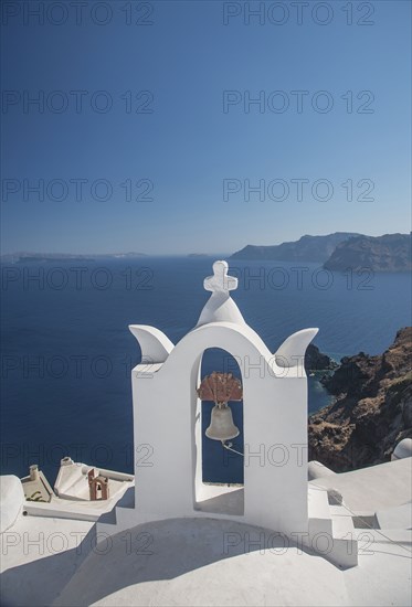 Church bell on hillside over seascape