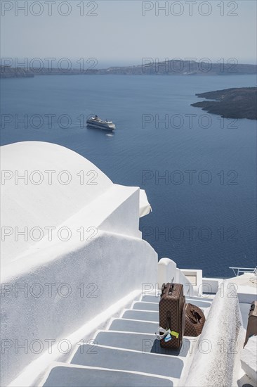 Suitcase on hillside steps over ocean