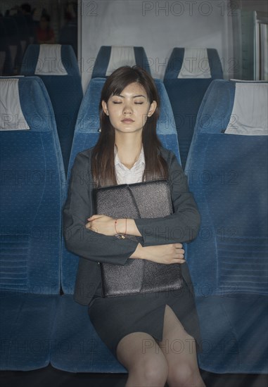 Chinese businesswoman napping on airplane