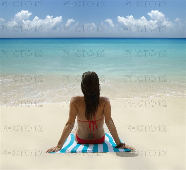 Caucasian woman laying on tropical beach