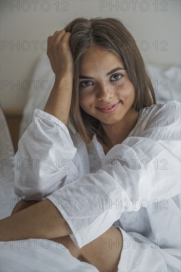 Caucasian woman smiling in bed