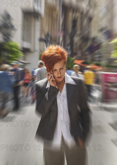 Caucasian businesswoman talking on cell phone in city