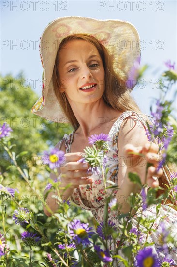 Caucasian woman admiring flowers