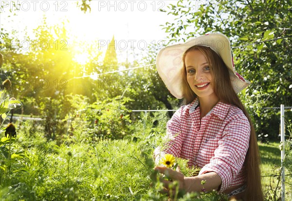 Caucasian woman examining plants in garden