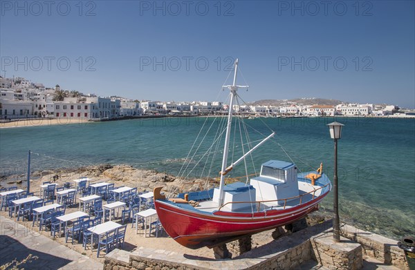 Boat and restaurant tables on oceanfront patio