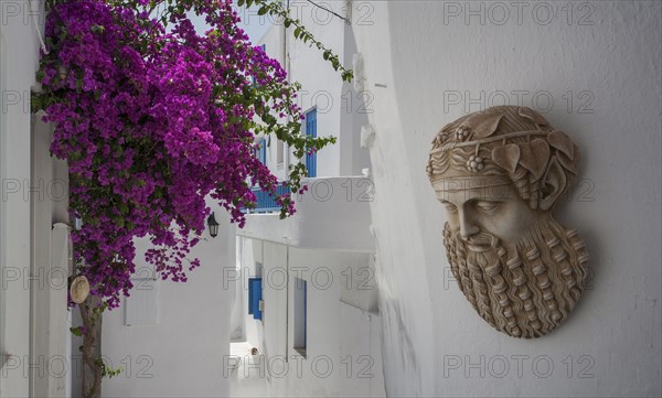 Sculpture and flowers on traditional building exterior