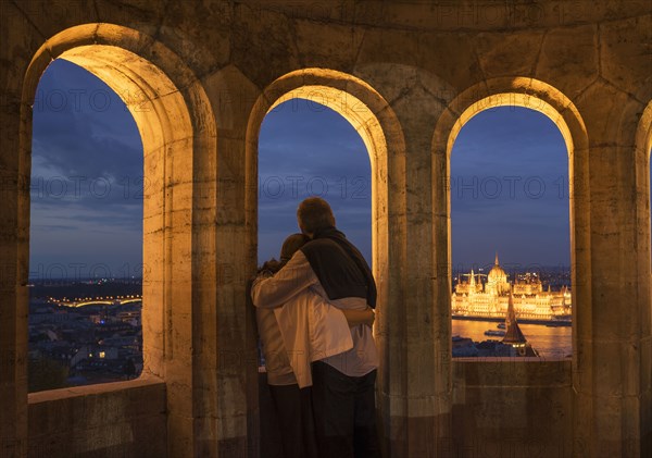 Tourists admiring cityscape from arch