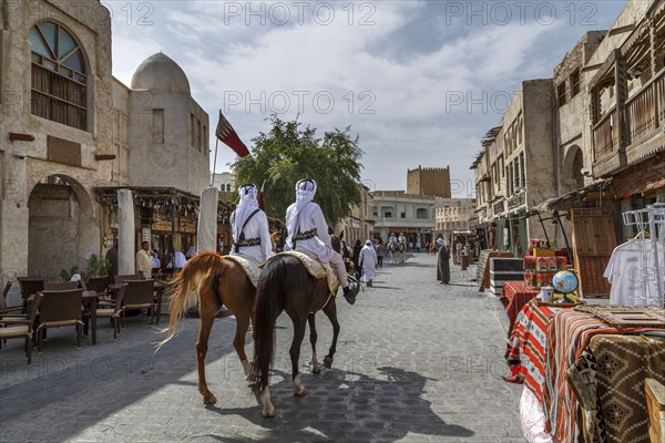 Men riding horses on Doha street
