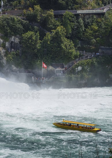 Boat floating near dramatic waterfall