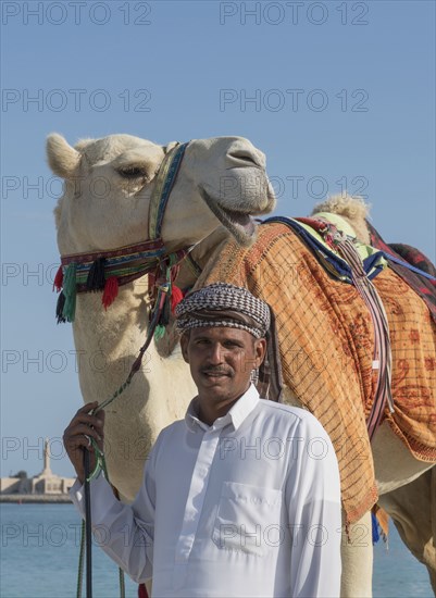 Middle Eastern man with camel near city