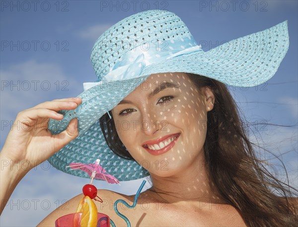 Caucasian woman drinking cocktail at beach