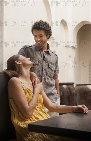 Smiling Caucasian couple holding hands at table outdoors