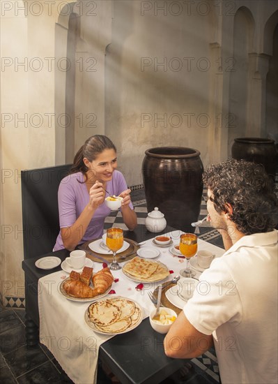 Smiling Caucasian couple eating at table