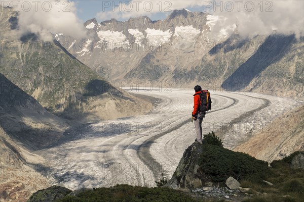 Caucasian man standing on rock in snowy mountains