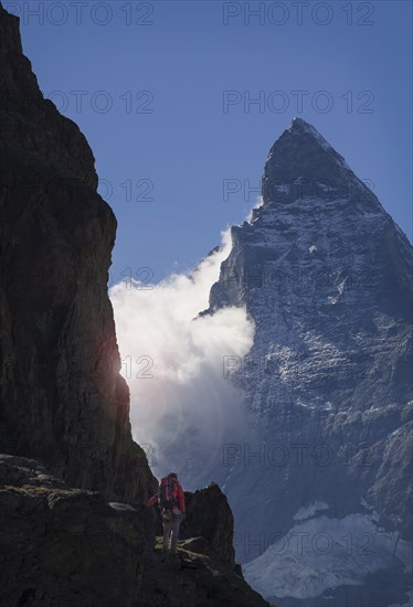 Man hiking in mountain near clouds