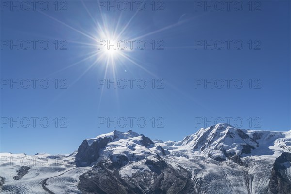 Snow on rocky landscape under sunny blue sky