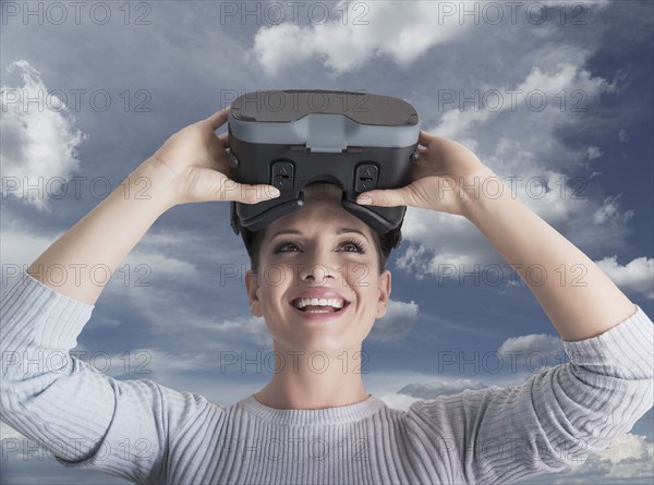 Caucasian woman removing virtual reality goggles